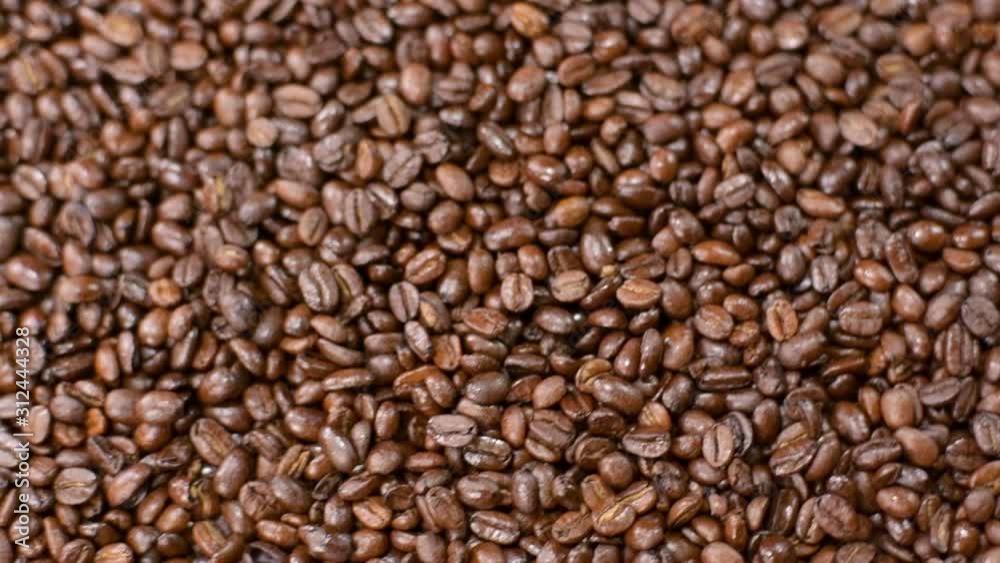 Fragrant coffee beans scrolls slowly around the camera in slow motion Fragrant coffee beans scrolls slowly around the camera in slow motion