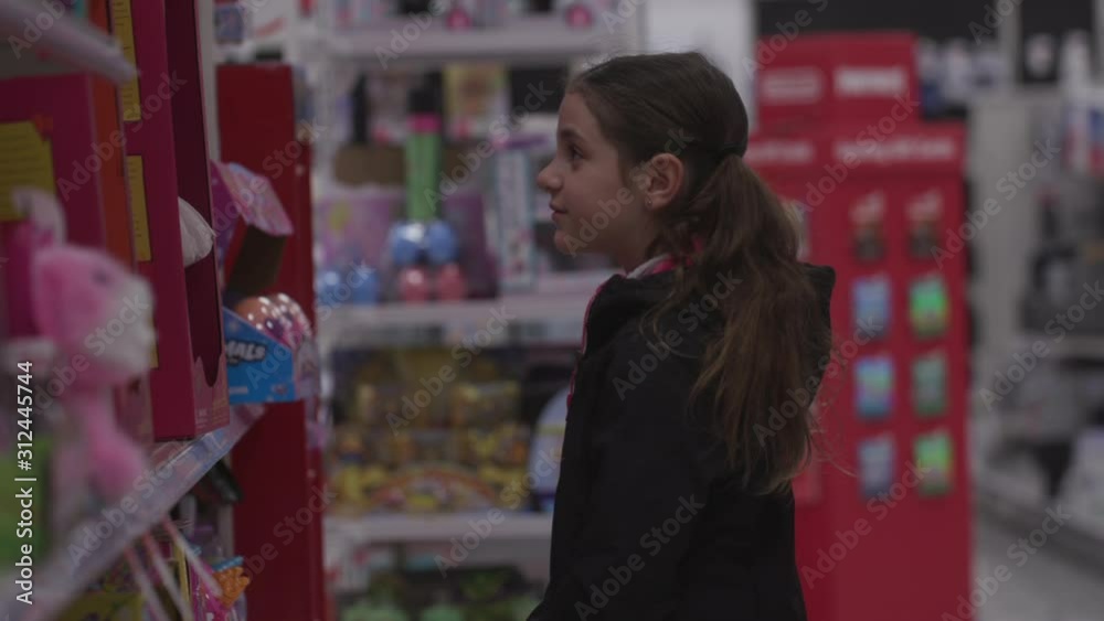 Adorable 8 years Girl With Brown Long Hair select Doll in toy section of Supermarket Adorable 8 years Girl With Brown Long Hair select Doll in toy section of Supermarket