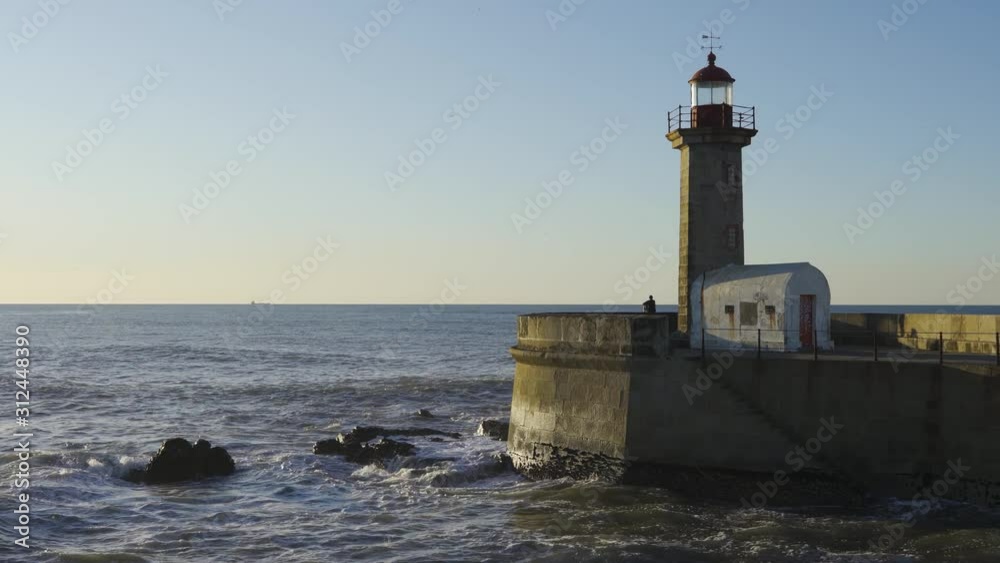 PORTO, PORTUGAL, December 2, 2019: very beautiful old lighthouse located on the mouth of the Douro river. Historic lighthouse facing some crushing waves in a soft winter light. PORTO, PORTUGAL, December 2, 2019: very beautiful old lighthouse located on the mouth of the Douro river. Historic lighthouse facing some crushing waves in a soft winter light.