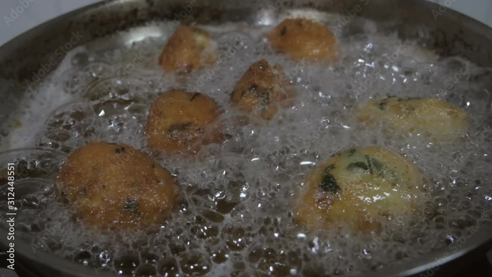 view from top codfish cakes boiling into oil pan view from top codfish cakes boiling into oil pan