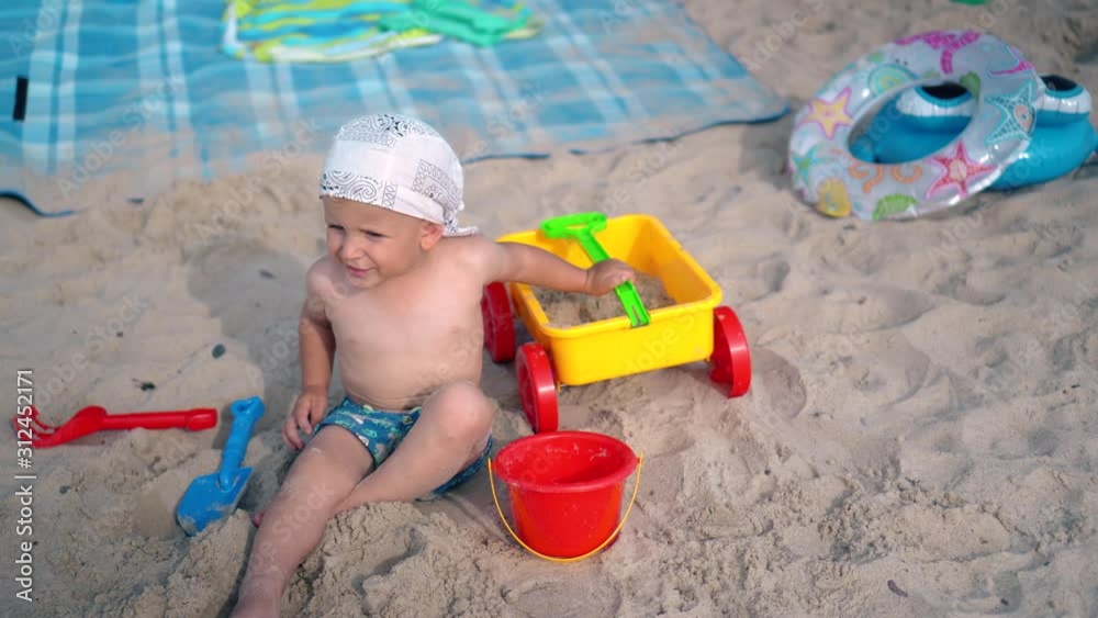 Toddler child play with sand and toys on beach. Family holidays concept Toddler child play with sand and toys on beach. Family holidays concept