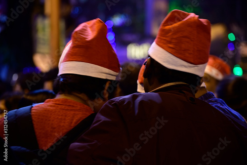 Boys are celebrating Christmas eve in night wearing Christmas cap on street at Kolkata. © suman