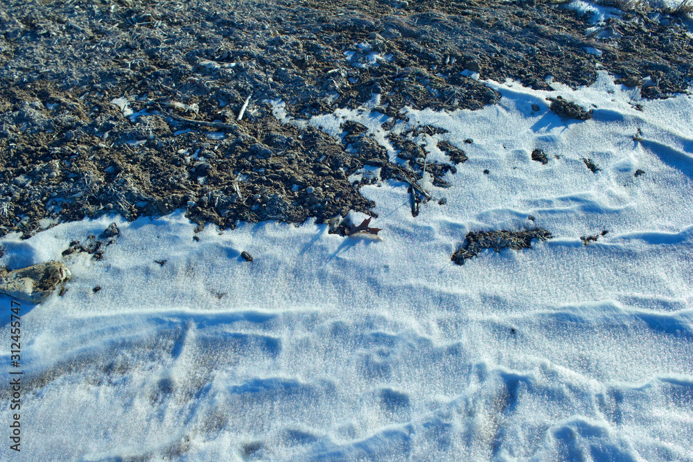 Close up abstract  texture background of snow drifted along a bare farm field ditch in winter