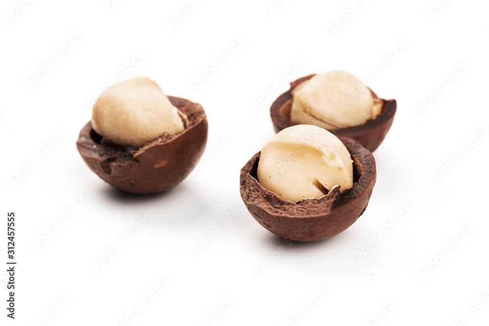 Raw not peeled whole macadamia nuts with shelled kernels isolated on white. Macro view. Healthy food. Protein source. Raw not peeled whole macadamia nuts with shelled kernels isolated on white. Macro view. Healthy food. Protein source.