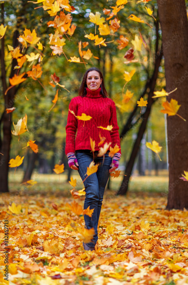 Young pretty woman walking in an autumn fall park with colourful trees Young pretty woman walking in an autumn fall park with colourful trees