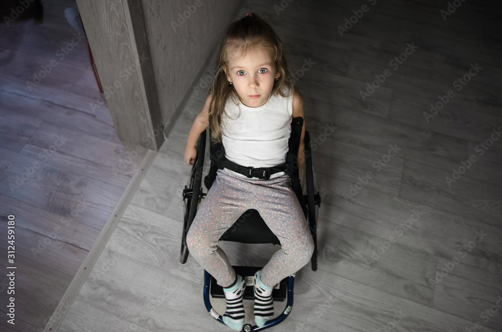 Beautiful sad girl child disabled child sitting in a wheelchair