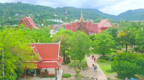CHALONG, THAILAND - APRIL 30, 2019: The view from Wat Chalong Pagoda on the pyathat roofs and ornate details of shrines and Ubosot, hidden among the lush tropical greenery, on April 30 in Chalong photo