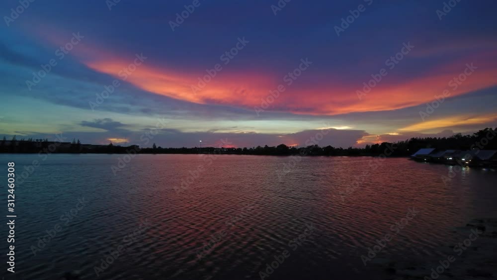 VDO. Aerial view evening of red clouds moving above the lake with dark blue sky background, twilight at Krajub reservoir, Ban Pong District, Ratchaburi, Thailand.