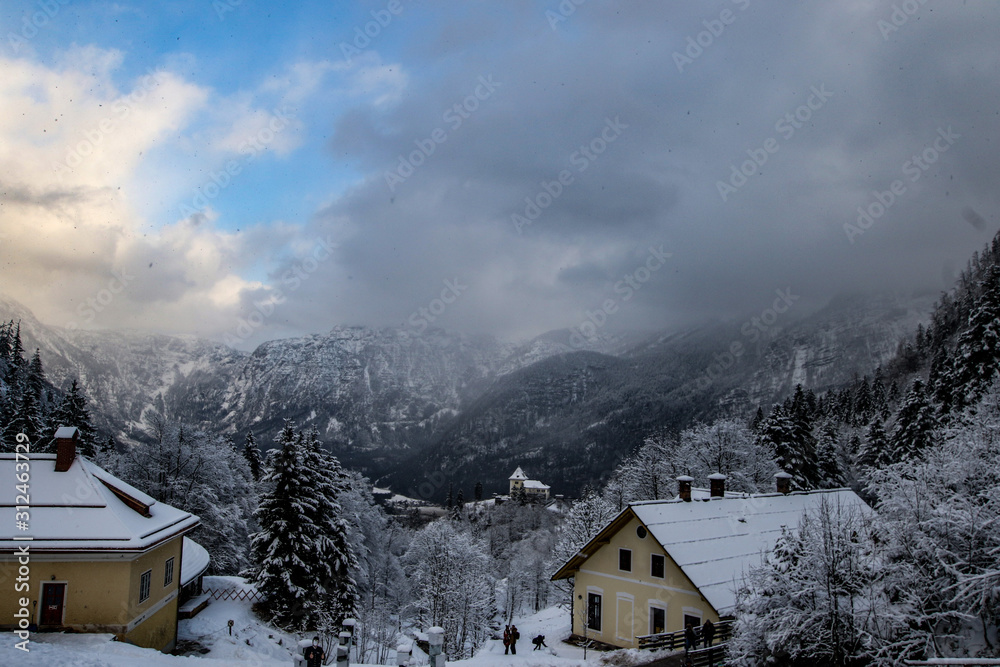 Beautiful Winter View of Hallstatt Austria in the Tyrolean Alps with dramatic sky and clouds