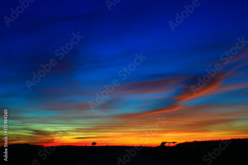 Very colorful clouds in dramatic sky. Romantic sunset at the countryside.