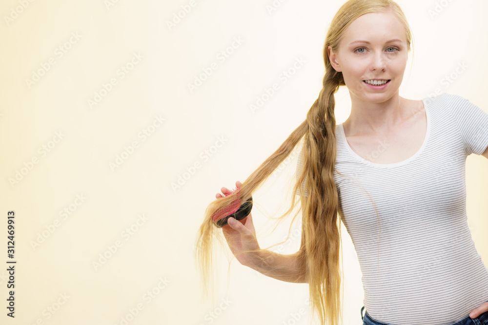 Blonde girl brushing her long hair
