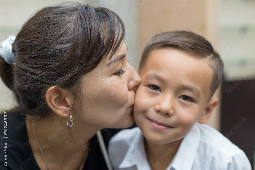 Happy mother and son, mom kisses her son Happy mother and son, mom kisses her son