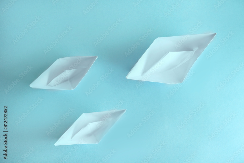 three paper boxes (origami technique) on a blue background. one ship is much larger than the rest. ships move from left to right, from top to bottom.. three paper boxes (origami technique) on a blue background. one ship is much larger than the rest. ships move from left to right, from top to bottom..