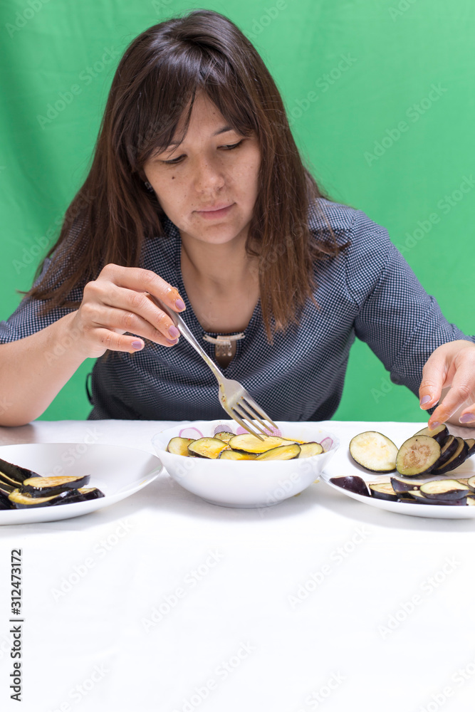 Girl preparing food on a table from eggplant Girl preparing food on a table from eggplant