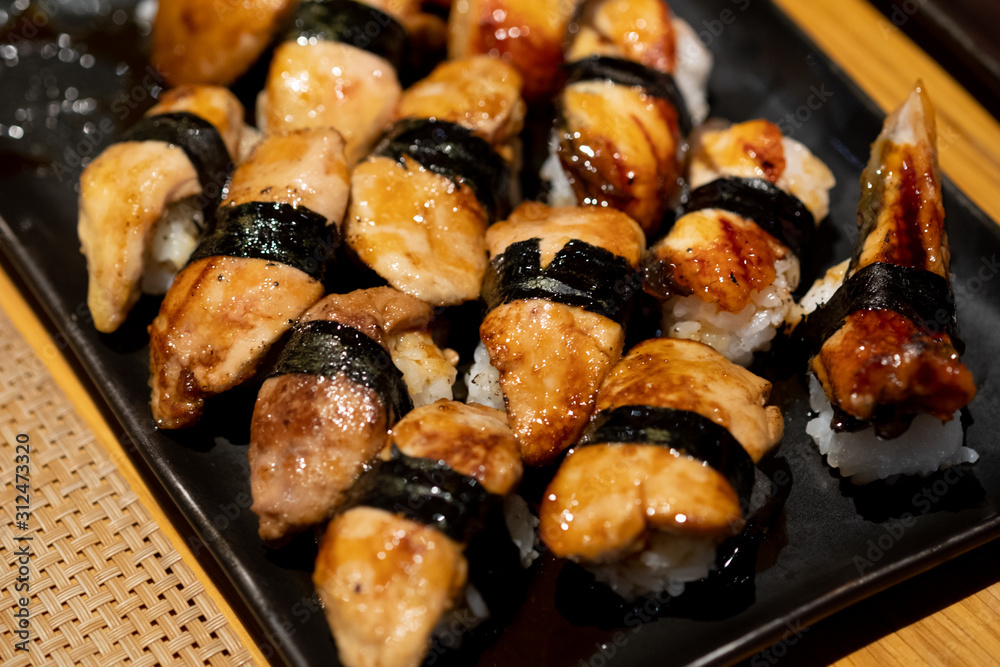 Foie Gras sushi and Unagi eel sushi on black tray
