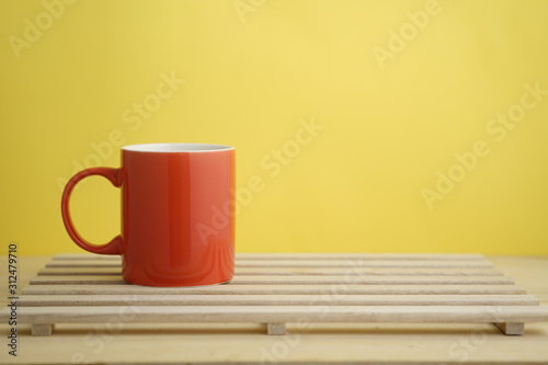 an empty pastel color mug on wooden base