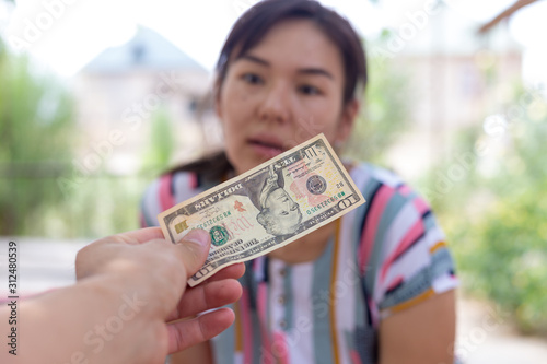 Offer dollar bills. A man offers a girl money for sex