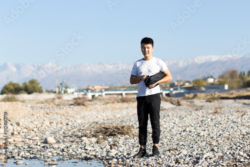 man in nature by the river with stones