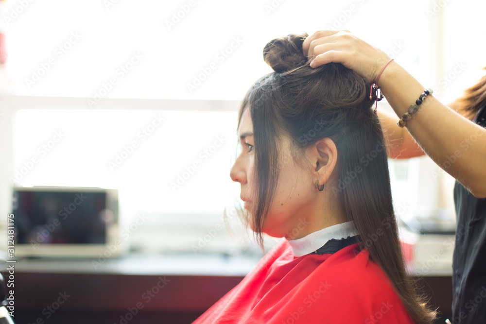 Naklejka premium Beautiful woman at the hairdresser blow drying her hair