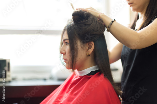 Beautiful woman at the hairdresser blow drying her hair
