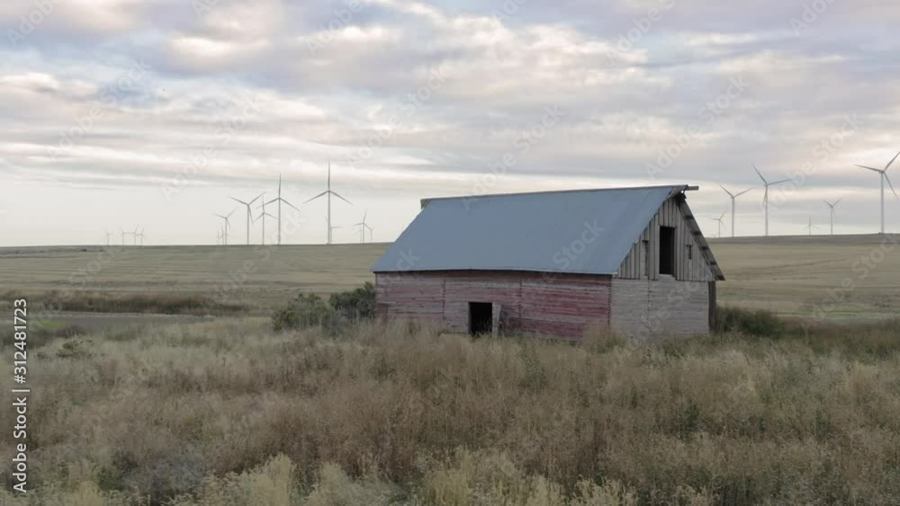 Aerial Of Old Abandoned Western Barn On A Ranch in Idaho. A wind farm is in the distance Aerial Of Old Abandoned Western Barn On A Ranch in Idaho. A wind farm is in the distance
