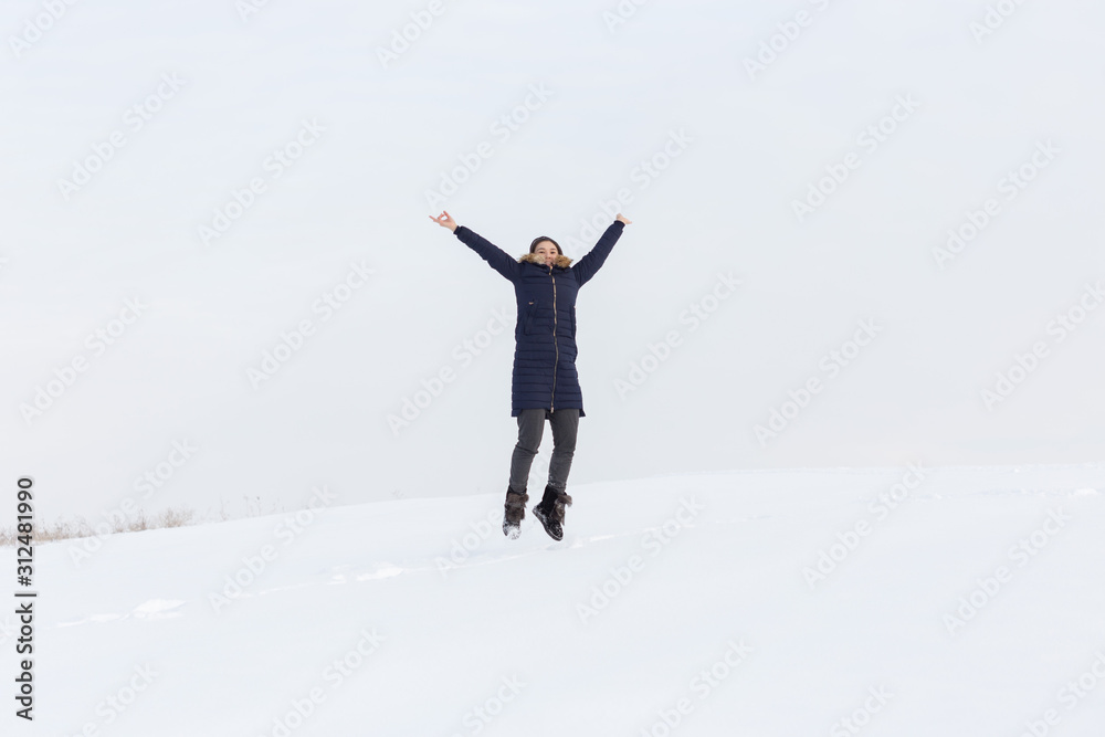 Portrait of a beautiful girl in blue jackets on the background of snow. Outdoor winter portrait Portrait of a beautiful girl in blue jackets on the background of snow. Outdoor winter portrait