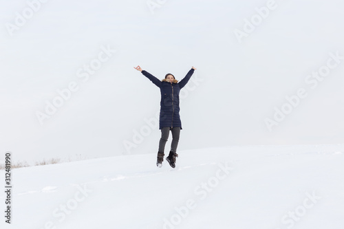 Portrait of a beautiful girl in blue jackets on the background of snow. Outdoor winter portrait