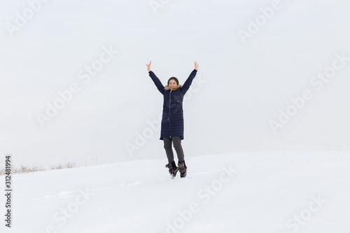 Portrait of a beautiful girl in blue jackets on the background of snow. Outdoor winter portrait © donikz