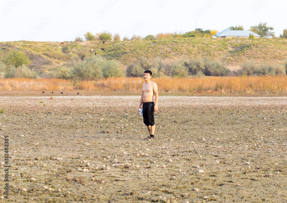 a young man walks in dirty, salty ecological places