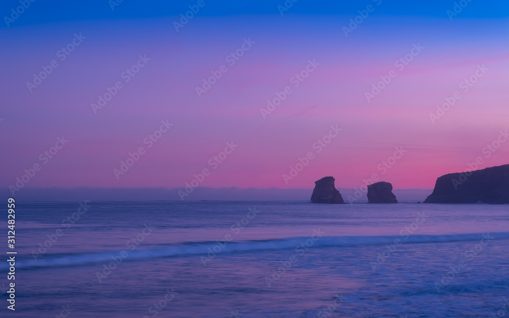 First lights of sunrise over the sea from Hendaye beach, France
