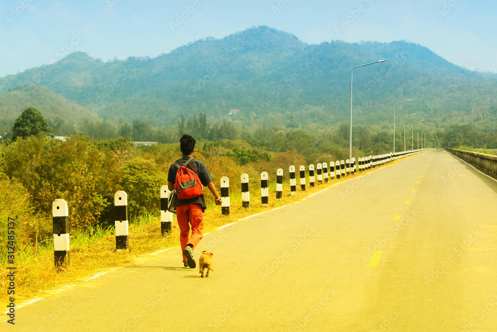 Obraz premium Running with the dog on a road with a forest background.
