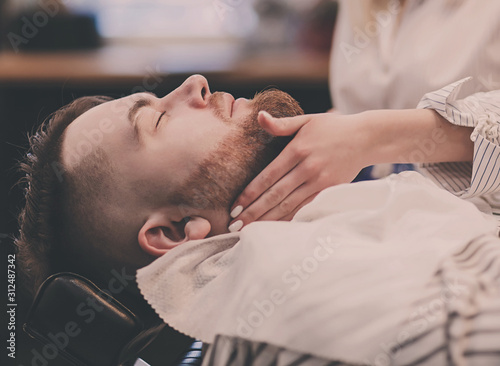 bearded man in a chair resting in a barbershop
