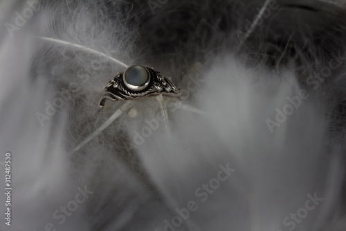 An extreme close-up and macro photograph of a detail of a soft white feather, black background.