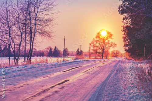 Rural winter landscape at sunrise. Country road covered with snow © vvvita