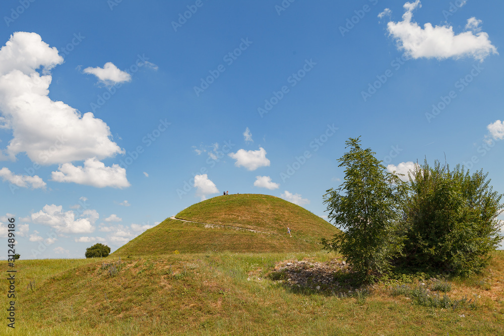 Ideal green round hill and blue sky with clouds above it. Krakus Mound, Krakow, Poland. - obrazy, fototapety, plakaty 