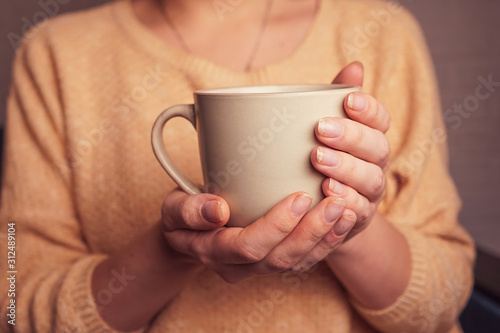 a girl holding in her hands a mug of coffee