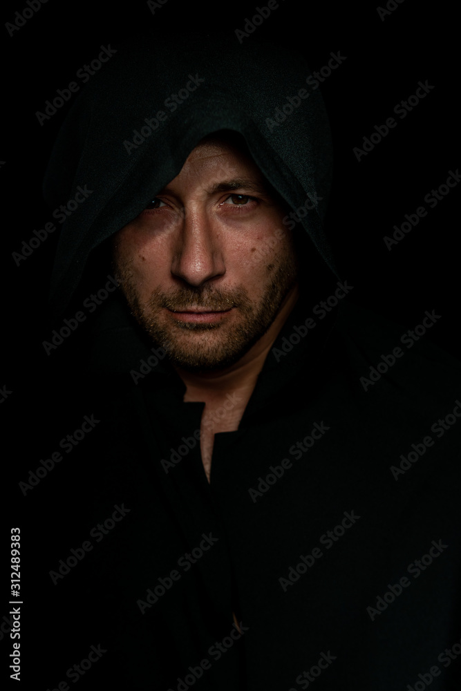 Portrait of a courageous warrior wanderer in a black cloak. Historical fantasy. Halloween Portrait of a courageous warrior wanderer in a black cloak. Historical fantasy. Halloween