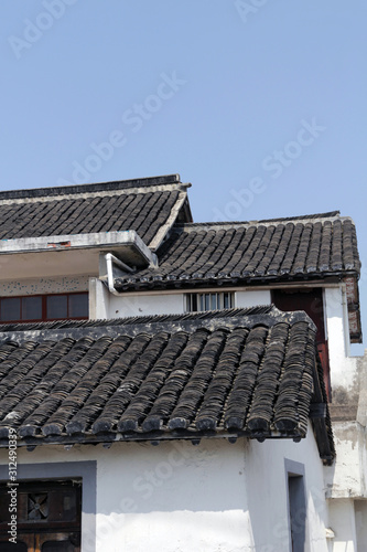 Features of a traditional southern Chinese house with grey roof tiles and white powder walls