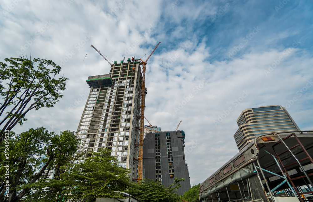 Fototapeta premium Construction site of building a high-rise building with a cranes against blue sky.