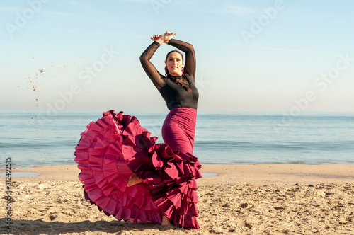 Young Spanish woman dancing flamenco on the beach