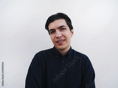 Young funny handsome stylish guy at white wall at background photo