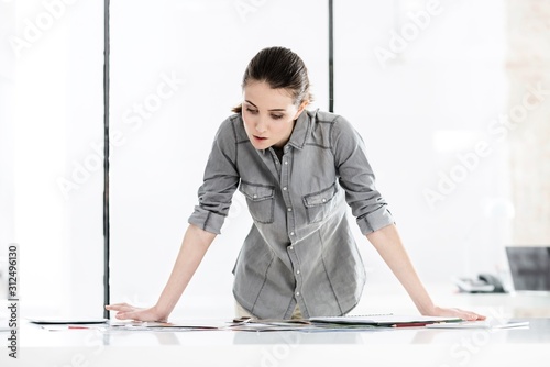 Portrait of young creative woman looking on the magazines