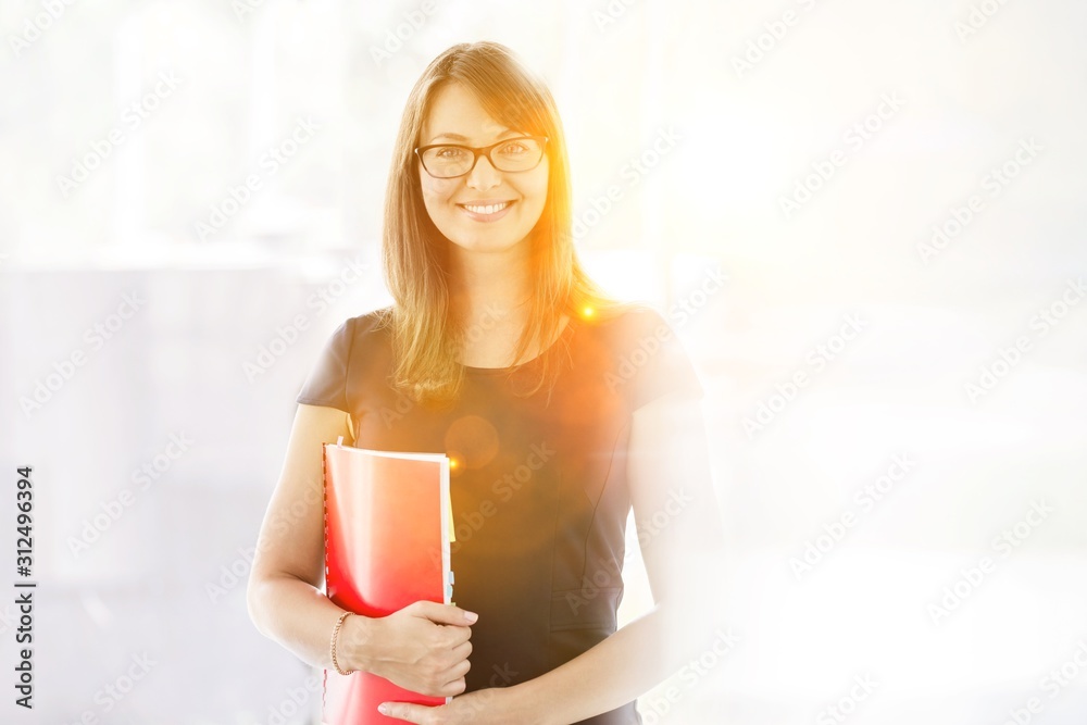 Portrait of smiling businesswoman holding document at office Portrait of smiling businesswoman holding document at office
