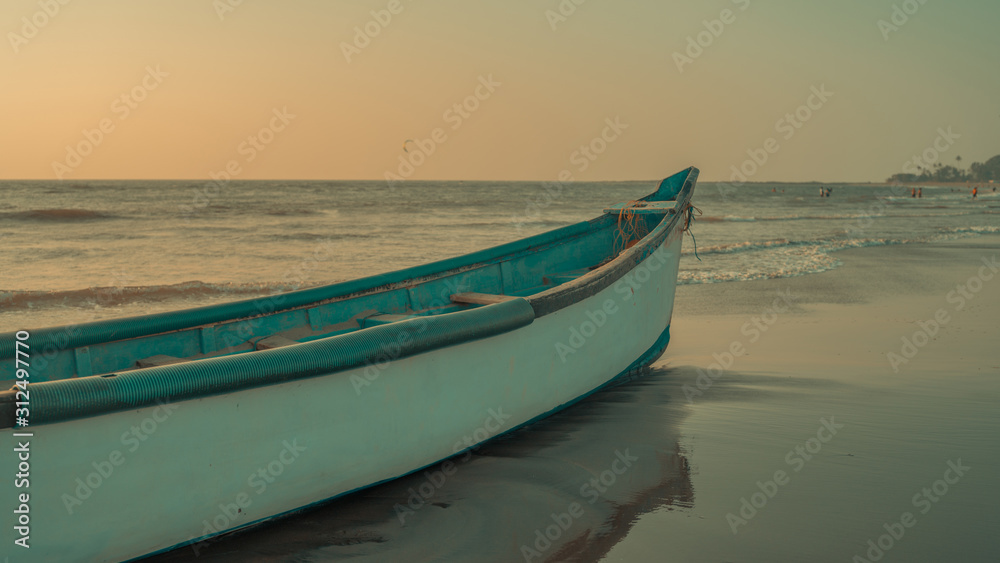 Empty boat on sandy beach in bright day. Large old white boat on sandy seaside ready to sail in bright day on beach