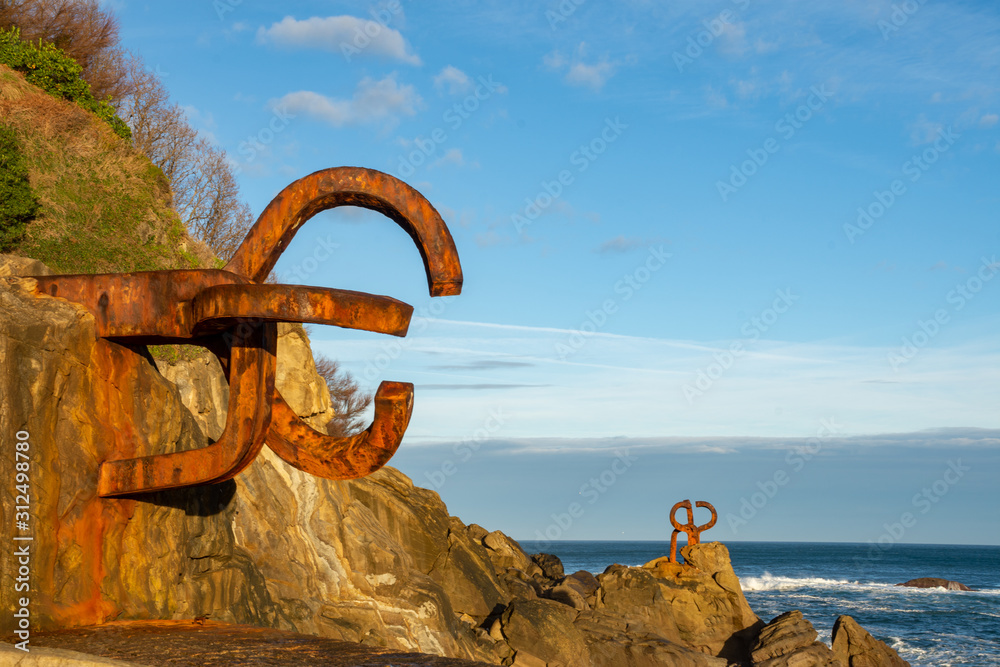 Fototapeta premium Panorama rzeźb grzebienia wiatru, o wschodzie słońca z błękitnym niebem, poziomo, w San Sebastian, Kraj Basków, Hiszpania