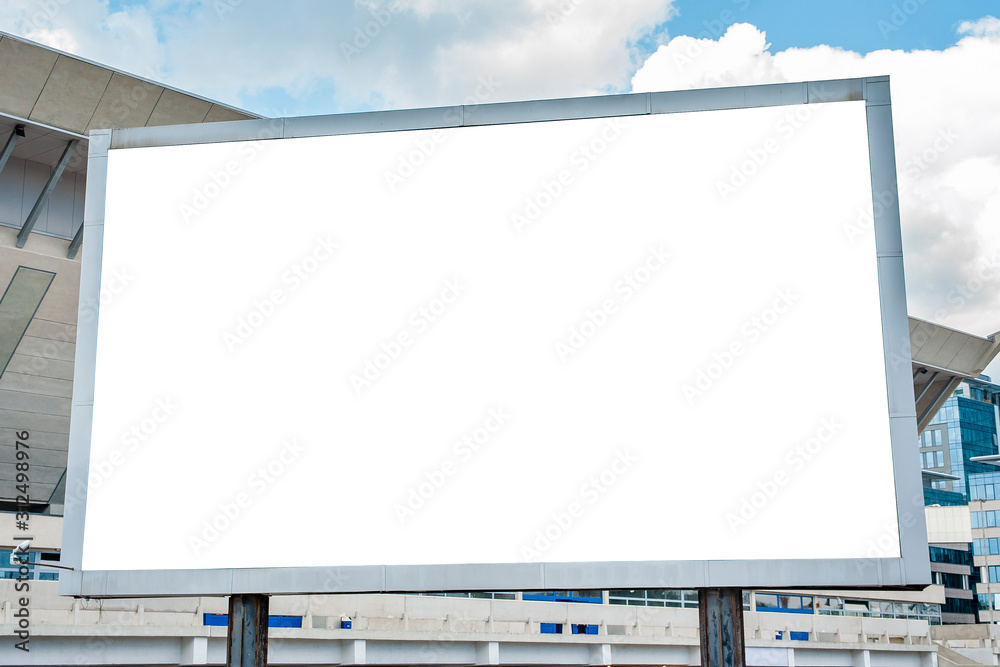 Advertising billboard mockup in front of modern office buildings - obrazy, fototapety, plakaty 