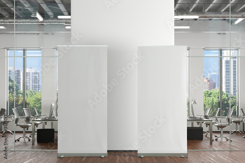 Blank roll up banner stand in office interior. 3d illustration