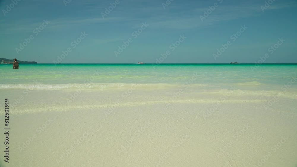 Tropical beach with tourists and clear blue sea. Summer and travel vacation concept. Boracay, Philippines Tropical beach with tourists and clear blue sea. Summer and travel vacation concept. Boracay, Philippines