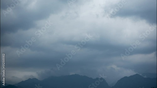 Timelapse of storm clouds rolling over Velebit Mountain Range in Paklenica National park, Croatia emerging from the clouds photo