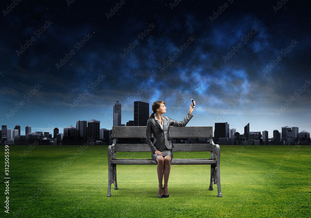 Business woman holding smartphone with raised hand Business woman holding smartphone with raised hand